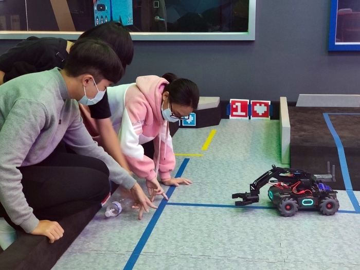 參賽者在龍華科大數位內容中心，體驗智慧機器人與Omni VR互動體感裝置。